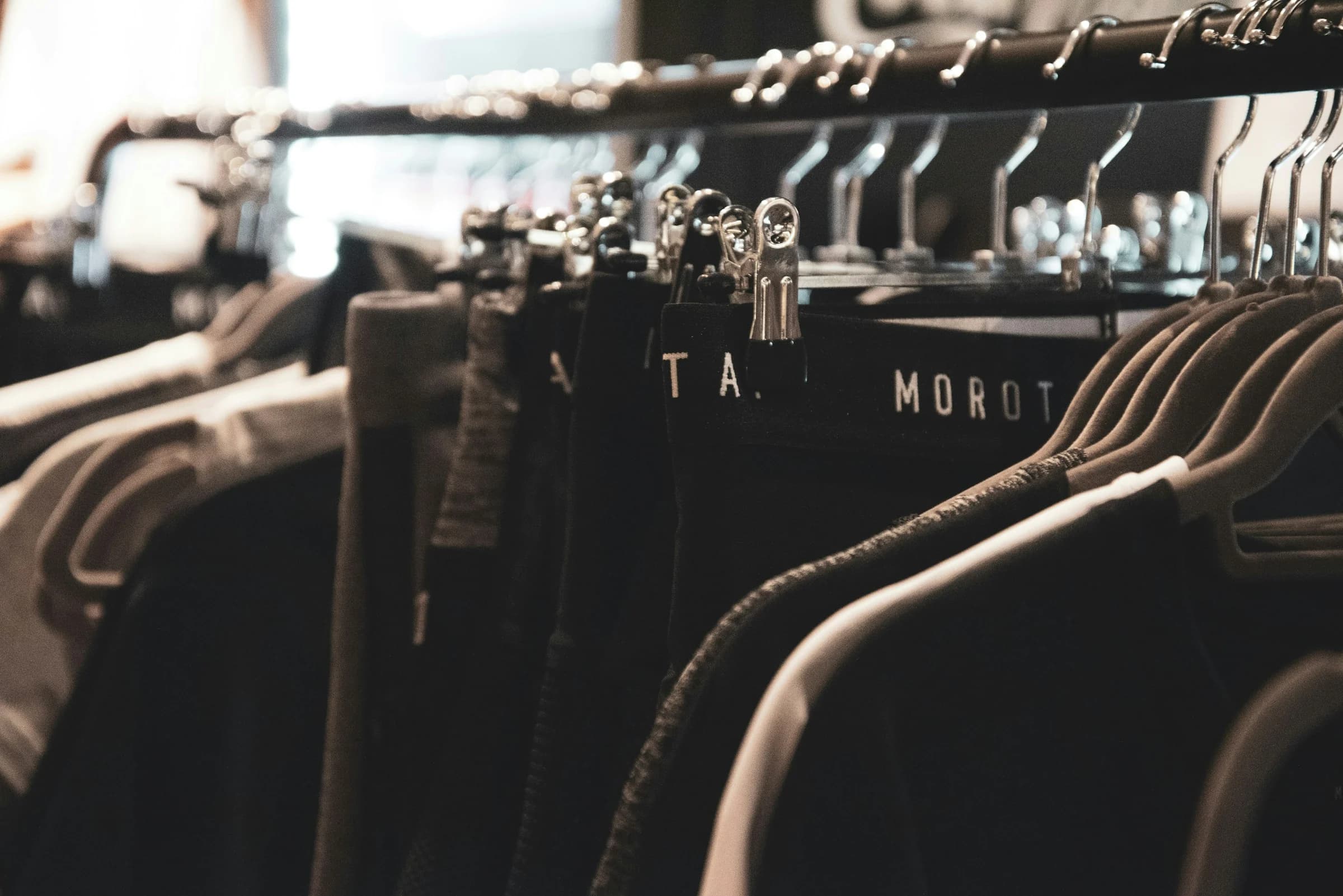 Dark clothing hanging from a rack inside an independent fashion shop